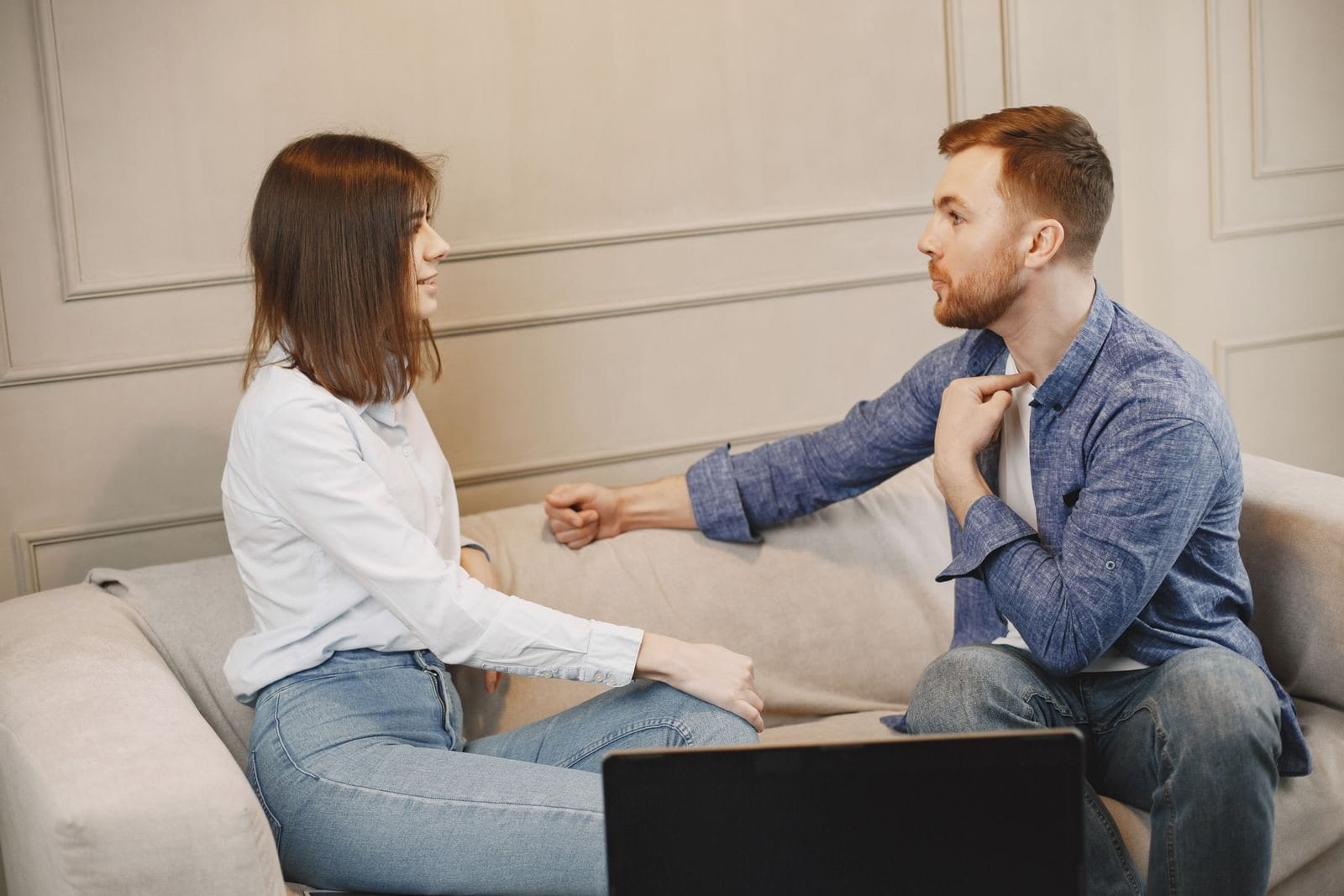 Two people talking together on a sofa