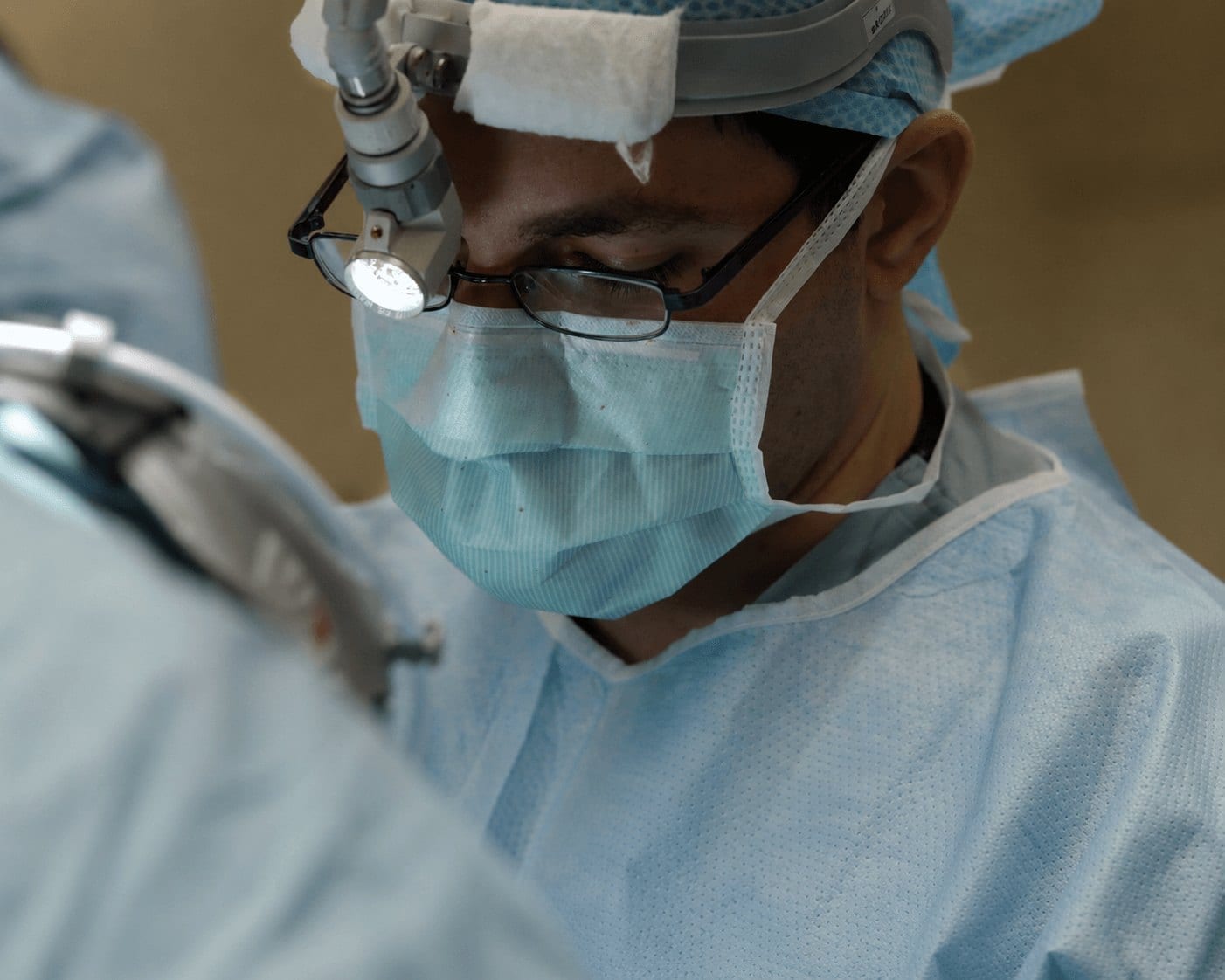 A physician in surgical loupes concentrating during a procedure